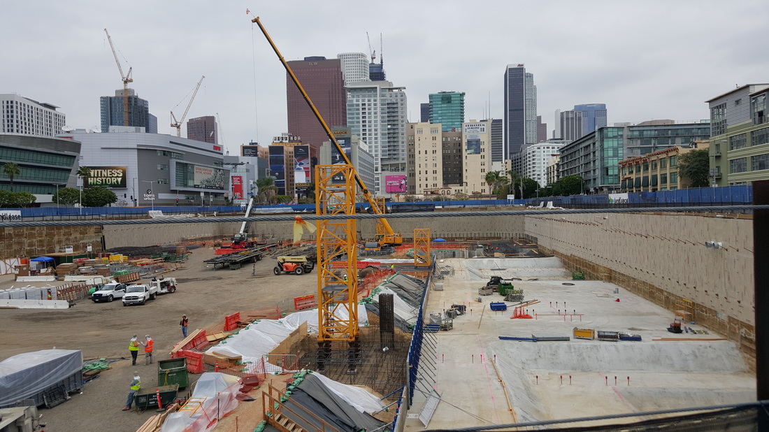Oceanwide Plaza construction site with construction cranes being installed. View of DTLA skyline with many cranes.